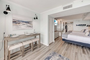 A bedroom with a bed, bedside tables, a desk with a chair, a painting on the wall, and a sign for 'BIG FISH'. - Direct Oceanfront Amazing Views In Camelot Resort (Myrtle Beach)