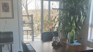 Ein Essbereich mit Tisch, Stühlen, einer Pflanze und einem Fernseher.