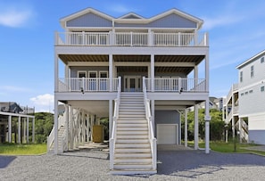 A two-story building with a central staircase, balconies, and a covered porch area. - Blue Dolphin: Oceanview, game room and Grill (North Topsail Beach)