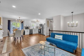 Eine moderne Wohnung mit Essbereich, Küche, Wohnzimmer und einer Treppe.
