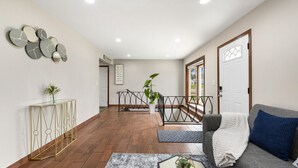 Un salon moderne avec un canapé, une table basse et une console sur laquelle est posé un vase.