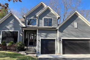 A two-story house with a front porch, a garage, and a small balcony. - Luxury Executive Retreat | Gym & Dual Office (Crystal Lake)