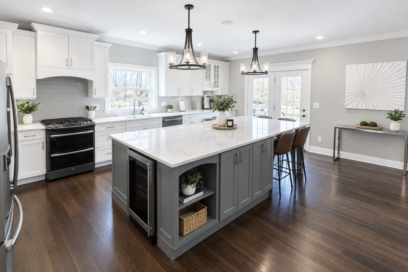 A modern kitchen with a large island, stainless steel appliances, and pendant lighting.