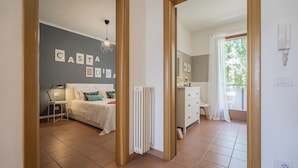 Ein Schlafzimmer mit Bett, Nachttisch, Lampe und Heizkörper.