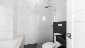 A modern bathroom with a glass-enclosed shower, a white toilet, and a bathtub. - 60sqm Pool Access Suite in Patong w/ Views C81 (Pataong)