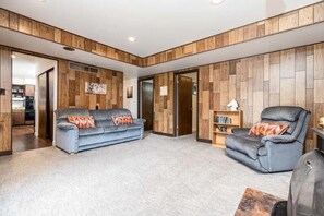 A living room with a grey sofa, a grey recliner, and a bookshelf. - Scenic Mountain Escape Near Cottonwoods w/Hot Tub (Sandy)