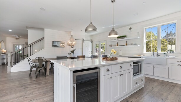A spacious kitchen with a large island, white cabinetry, and pendant lighting. - Serene 5BR Farmhouse Retreat Shoreline (Shoreline)