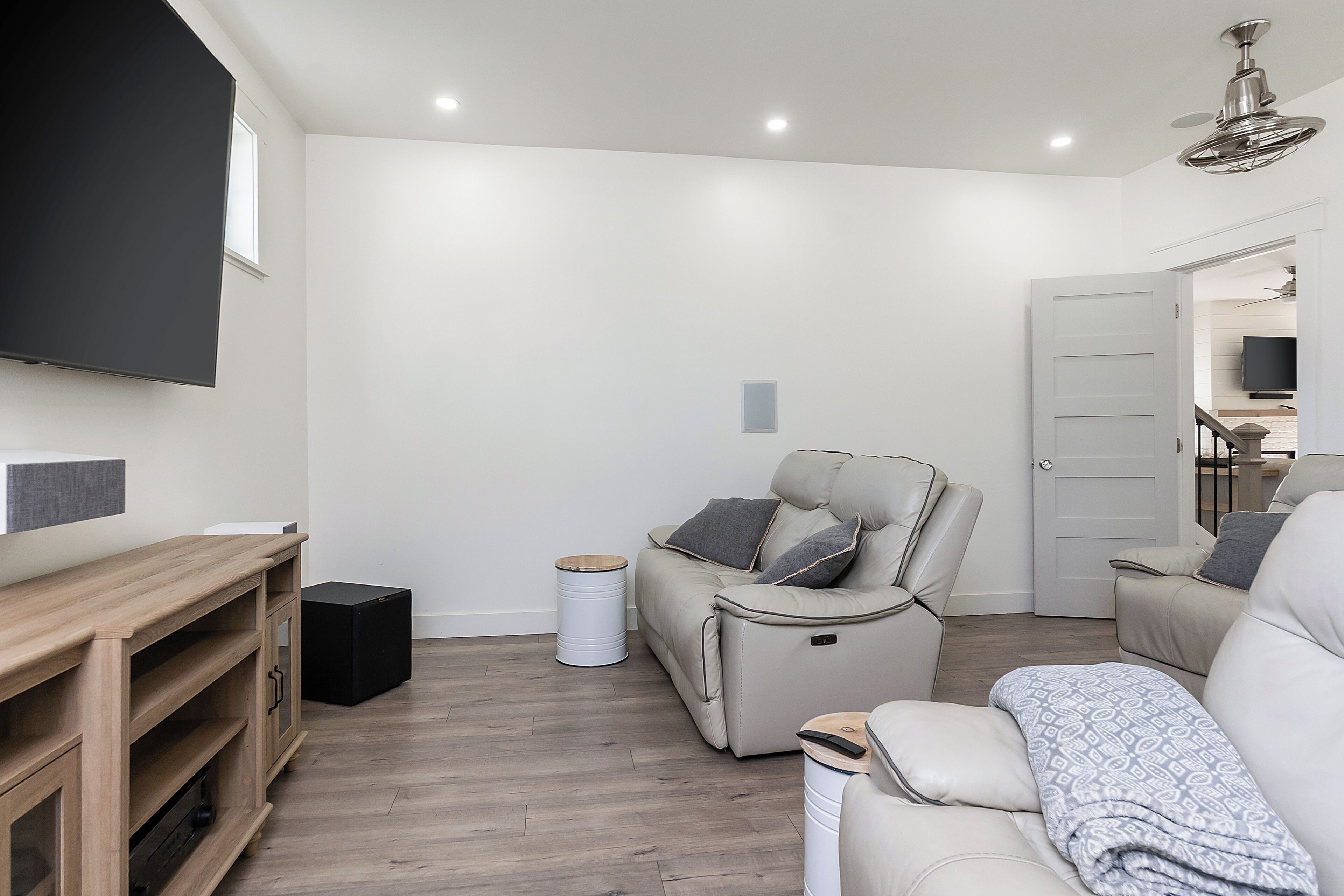 A modern living room with a sofa, a TV, and a wooden entertainment unit.