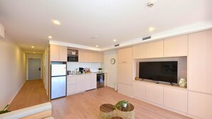 A modern apartment with a kitchen, living area, and a TV. - Coastal 1BR Retreat – Steps to New Brighton Beach (Christchurch)