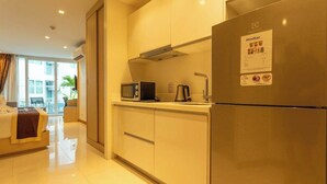 Una cuina moderna amb microones integrat, cafetera i nevera amb cartell de Minibar.