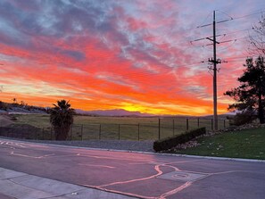 A sunset over a rural landscape with a road, utility poles, and a fenced area. - Spacious 3BR/2RR AC Mountain View New Home (Bakersfield)