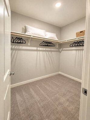 A closet with hanging space, a shelf with a basket, and a door with a handle. - Spacious 3BR/2RR AC Mountain View New Home (Bakersfield)