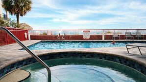 A swimming pool with a no diving sign, a red fence, and a palm tree in the background. - Upscale Beachfront Condo • Gulf View Balcony • Pool• Steps to Johns Pass &Dining (Madeira Beach)
