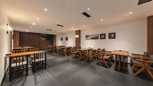 A modern conference room with wooden tables and chairs, recessed ceiling lights, and framed pictures on the walls. - Wuye WOO YEAH Tangchi Hotel (Leshan)