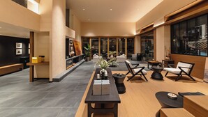 A spacious lobby with a long reception desk, seating area, and large windows. - Wuye WOO YEAH Tangchi Hotel (Leshan)