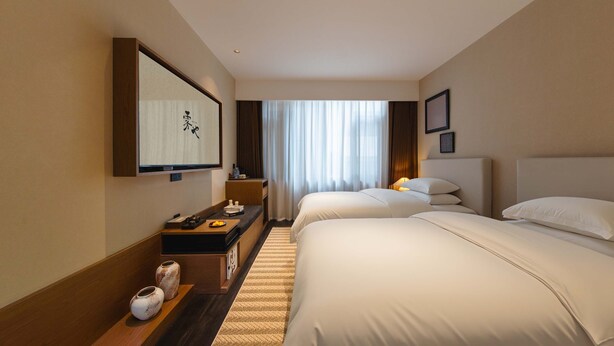A hotel room with two beds, a desk with a computer, a flat-screen TV, and a large window with curtains. - Wuye WOO YEAH Tangchi Hotel (Leshan)