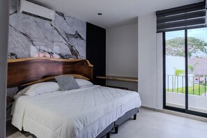 Une chambre moderne avec un grand lit, un mur en marbre, une tête de lit en bois et un balcon avec vue.