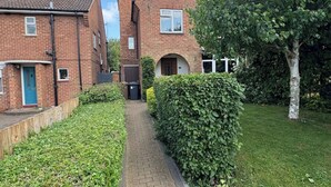 Un quartier résidentiel avec des maisons en briques, un chemin et une haie.