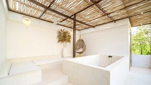 A modern bathroom with a freestanding bathtub, a ceiling fan, and a hanging chair. - Casa Myla Villa - Bingin Bali (Munggu)