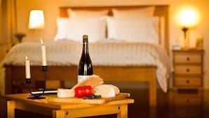 A bedroom with a bed, bedside table, lamp, and a nightstand with a lamp.
