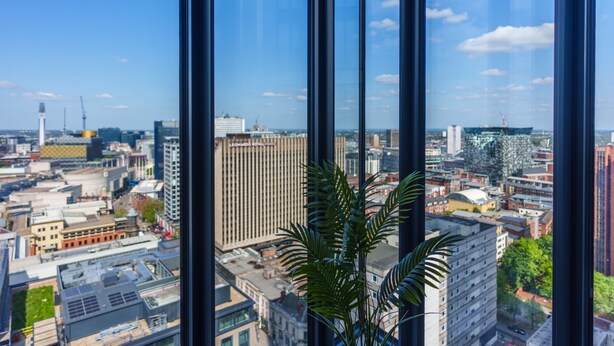 En hög byggnad med stora fönster som ger utsikt över stadsbilden.