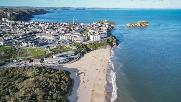 An aerial view of a coastal town with a sandy beach, a prominent church, and a castle on a small island. - The Burrows - 3 Bedroom Holiday Home - Tenby (Tenby)