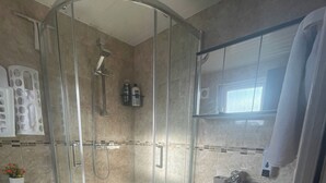 A bathroom with a glass-enclosed shower, a sink, and two toilets. - Tottenham - Sleeps 10 - Garden - Near Transport (London)