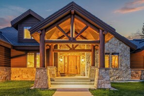 A house with a stone facade, a wooden porch with a gabled roof, and a front door. - Abode at Trail Creek Canyon, views, hot tub, games (Oakley)