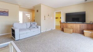 Una sala de estar con un sofá, un televisor y un mueble de madera.