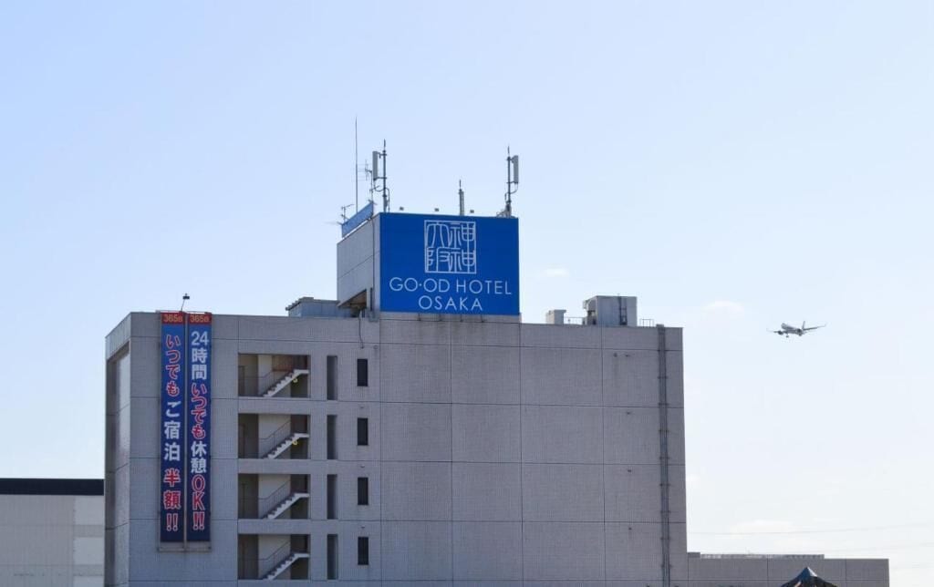 A building with a sign for 'GO-OD HOTEL OSAKA' and a staircase leading to an upper floor.