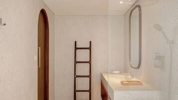 Un baño moderno con separador de vidrio, escalera de madera, lavamanos con espejo e inodoro.