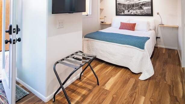 Une chambre à coucher avec un lit, une télévision, un plafond en bois et une fenêtre.