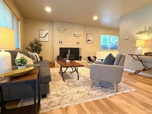 A living room with a fireplace, a sofa, a coffee table, and a lamp.