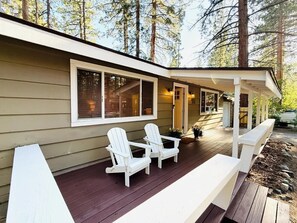 A house with a covered porch, two white Adirondack chairs, and a wooden deck. - Bijou Tahoe Cabin - Walk to Lake, Near Casinos! (South Lake Tahoe)