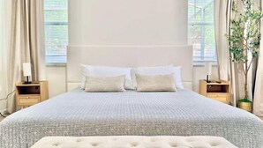 A bedroom with a large bed, two bedside tables, and a window with curtains. - Stunning 4BR Pool Home Your Private Oasis Awaits (Davenport)