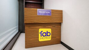 A reception desk with a 'RECEPTION' sign and a 'fab HOTELS' logo. - Fabhotel Aarvi Inn (Chhatrapati Sambhajinagar)