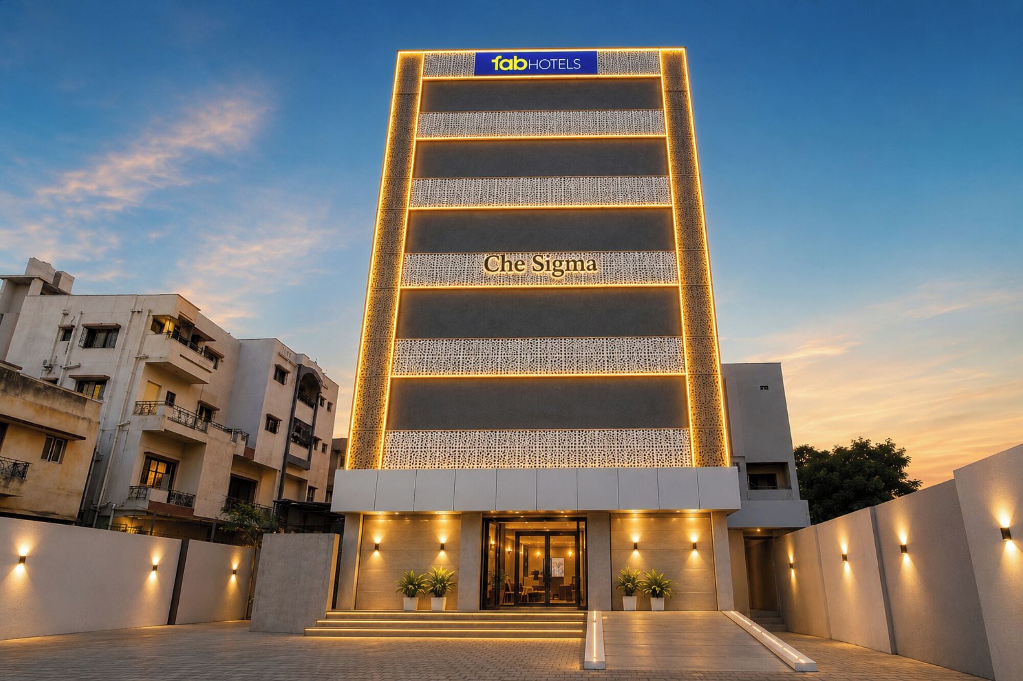 Un bâtiment d’hôtel doté d’une façade moderne, d’une enseigne bien visible indiquant « fabHOTELS », et du nom « Che Sigma » affiché sur le côté.