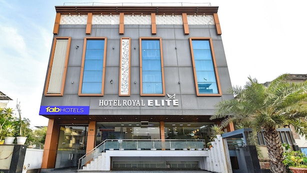 Un moderno edificio de hotel con un letrero llamativo que dice 'HOTEL ROYAL ELITE' y un letrero de 'fabHOTELS' debajo.