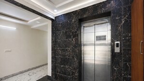 A modern elevator with a metallic finish, set in a hallway with marble flooring and walls. - FabHotel The Royal Residency - Dashrathpuri Metro (New Delhi)