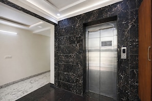 A modern elevator with a metallic finish, set in a hallway with marble flooring and walls. - FabHotel The Royal Residency - Dashrathpuri Metro (New Delhi)