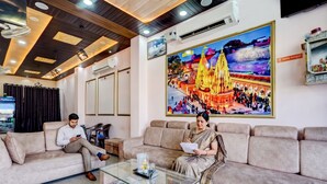 A modern hotel lobby with a large wall mural, a glass coffee table, and a seating area. - FabHotel Chandra Dreams - 600m from Banaras Railway Station (Varanasi)