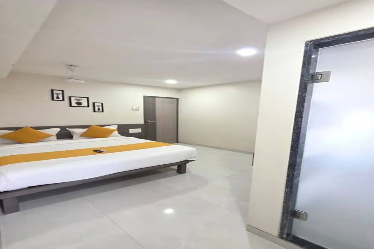 A hotel room with a bed, a door, and a ceiling fan.