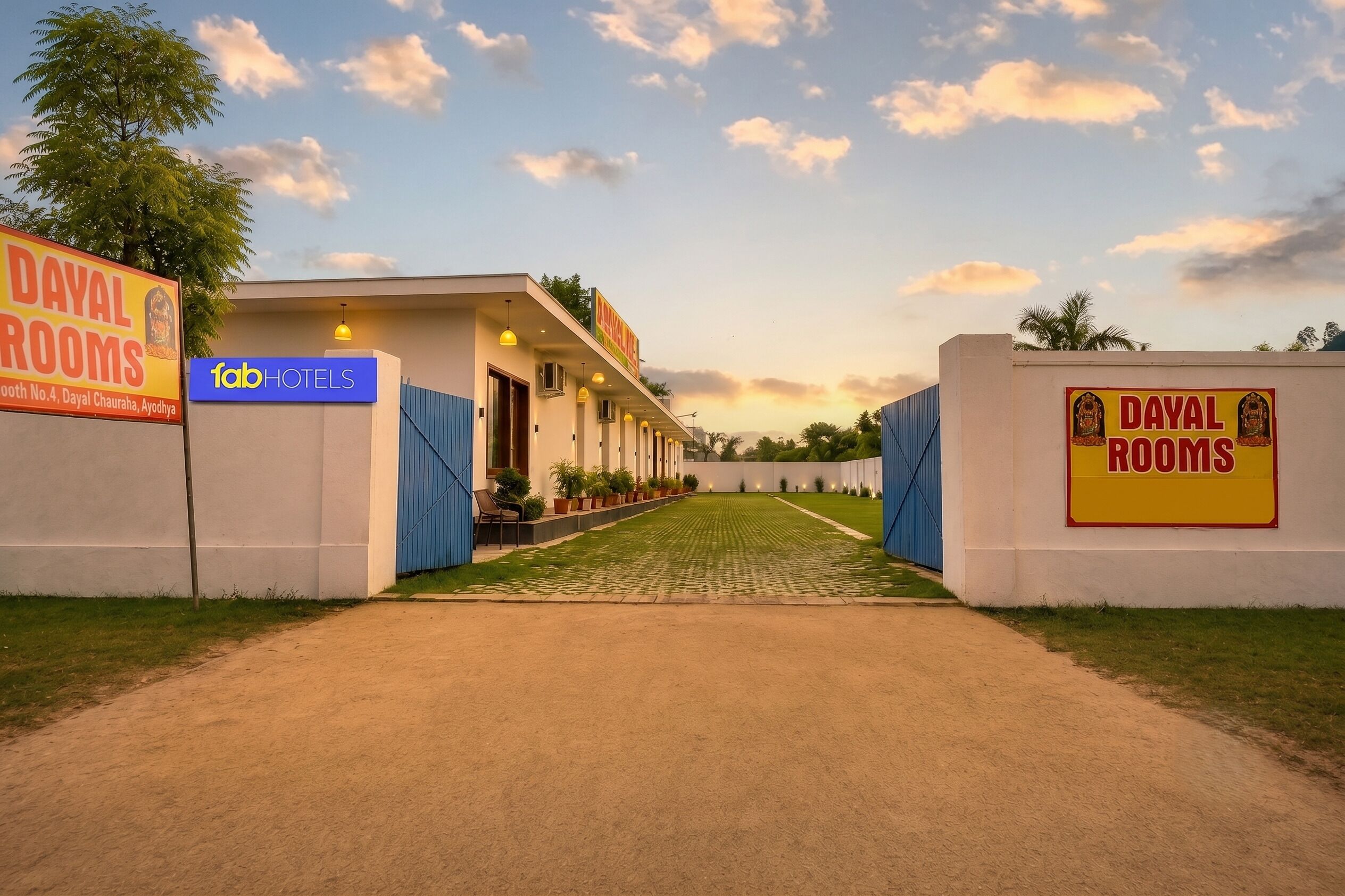 A hotel entrance with a sign for 'Dayal Rooms' and 'Fab Hotels' on the facade.