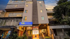 A multi-story hotel with a sign for 'fah hotels' and a 'MALIK HOUSE' sign indicating a ground floor restaurant. - FabHotel Casa Royal - Greater Kailash (New Delhi)