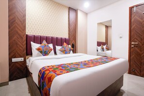 Una habitación de hotel con cama, espejo, armario y teléfono.