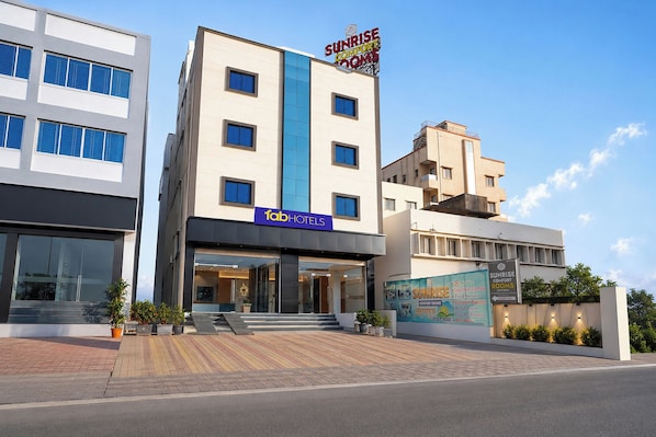 A modern hotel with a sign for 'Sunrise Comfort Rooms' and 'Fab Hotels.' - Fabhotel Sunrise Comforts (Pune)