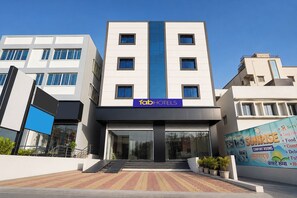 A modern hotel building with a prominent 'fab hotels' sign, a central entrance with steps, and a large glass facade. - Fabhotel Sunrise Comforts (Pune)