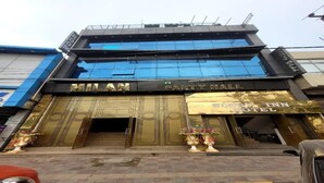 A building with a sign for 'Milan Party Hall' and 'Bless Hotel.' - Fabhotel Blest Inn (New Delhi)
