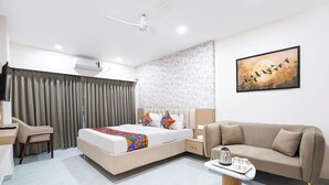 A modern hotel room with a bed, a sofa, a desk, and a coffee table. - Fabhotel Sahyadri Mantram (Pune)
