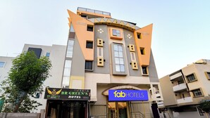 Et hotel med moderne design, med et tydeligt 'fab hotels' skilt og et 'BR GREEN'S HOTEL' skilt.